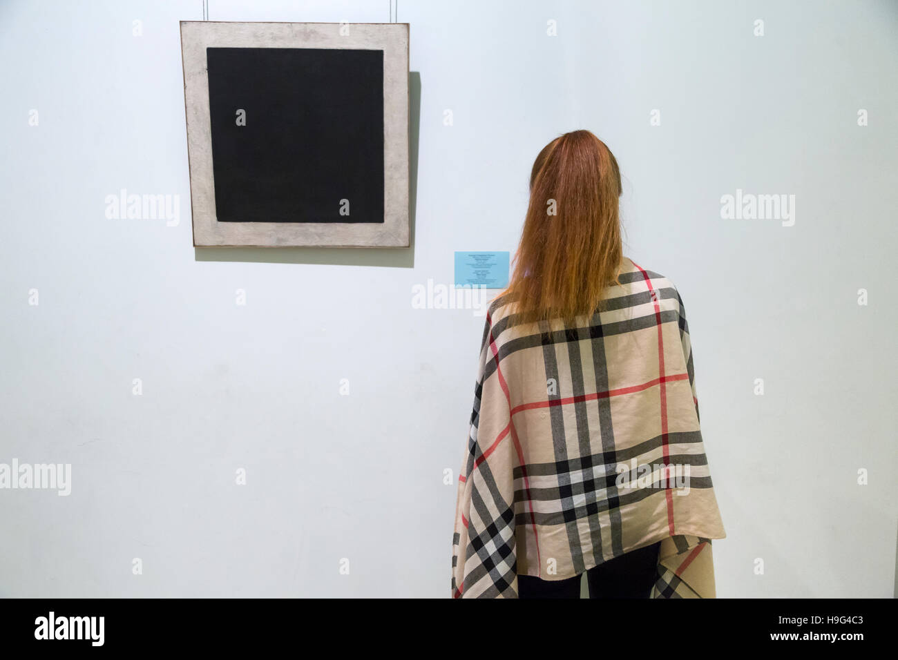 A visitor in front of Kazimir Malevichs painting 'Black Suprematist Square' at The Hermitage Gallery in St Petersburg, Russia Stock Photo