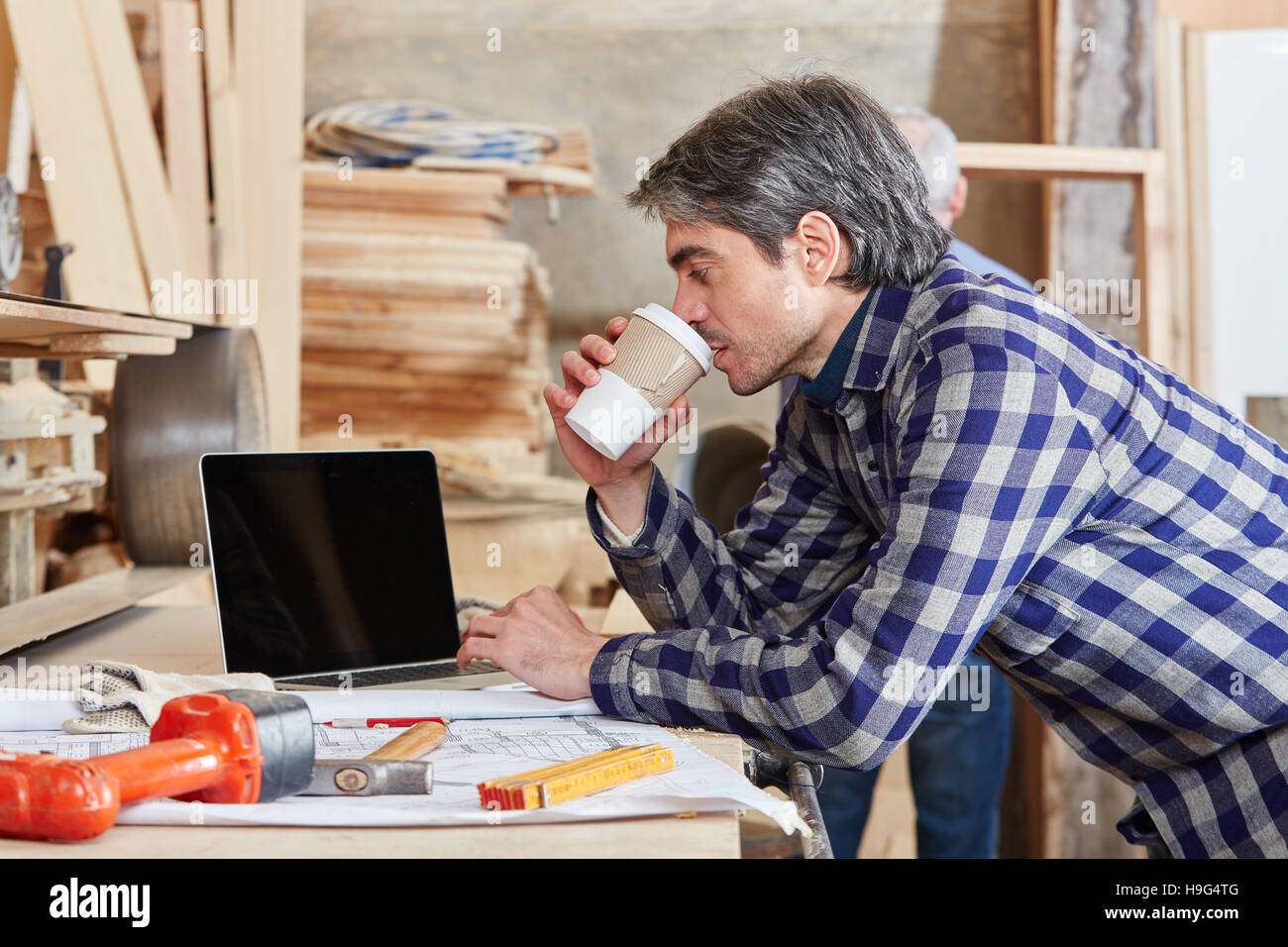 Artisan taking a coffee break at carpentry workshop Stock Photo