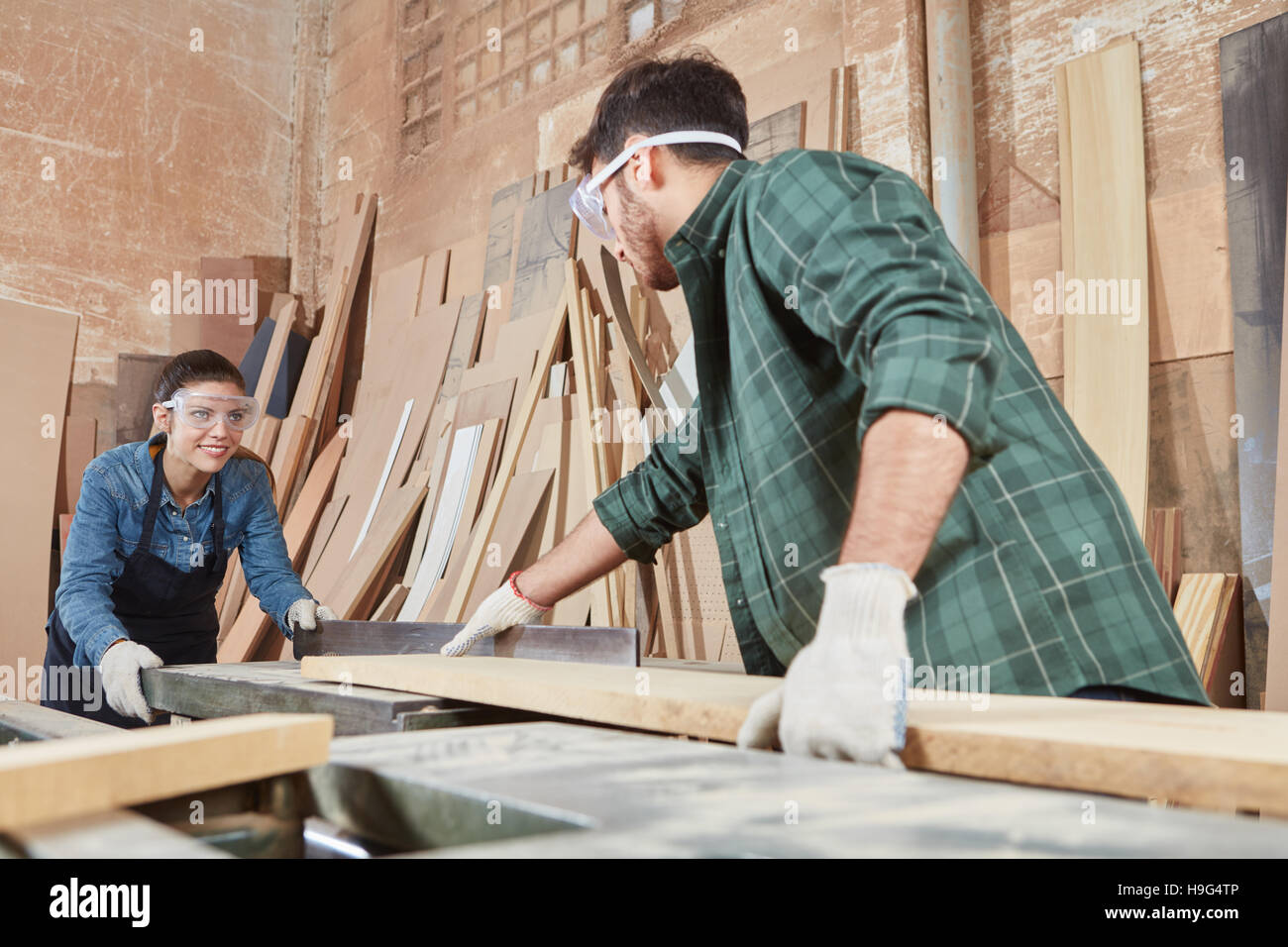 Woman and man teamwork at carpentry shop Stock Photo - Alamy