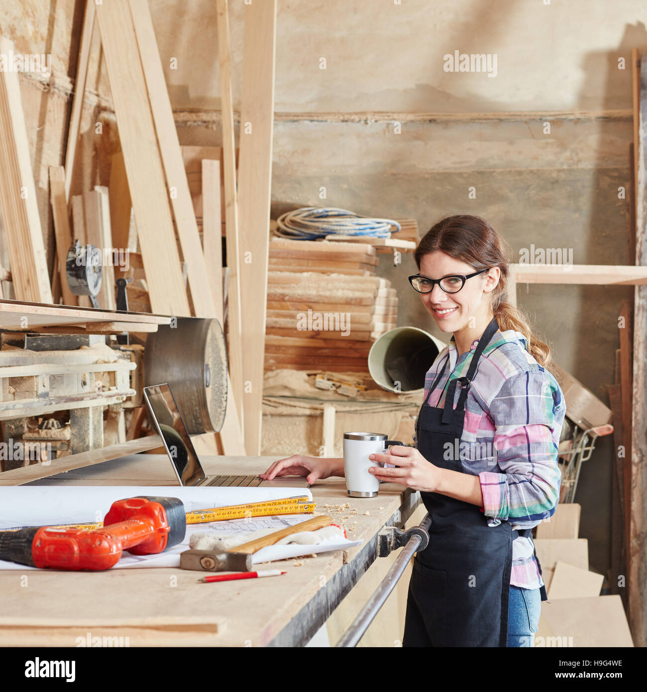 Woman as carpentry apprentice drinking coffee at workbench Stock Photo ...