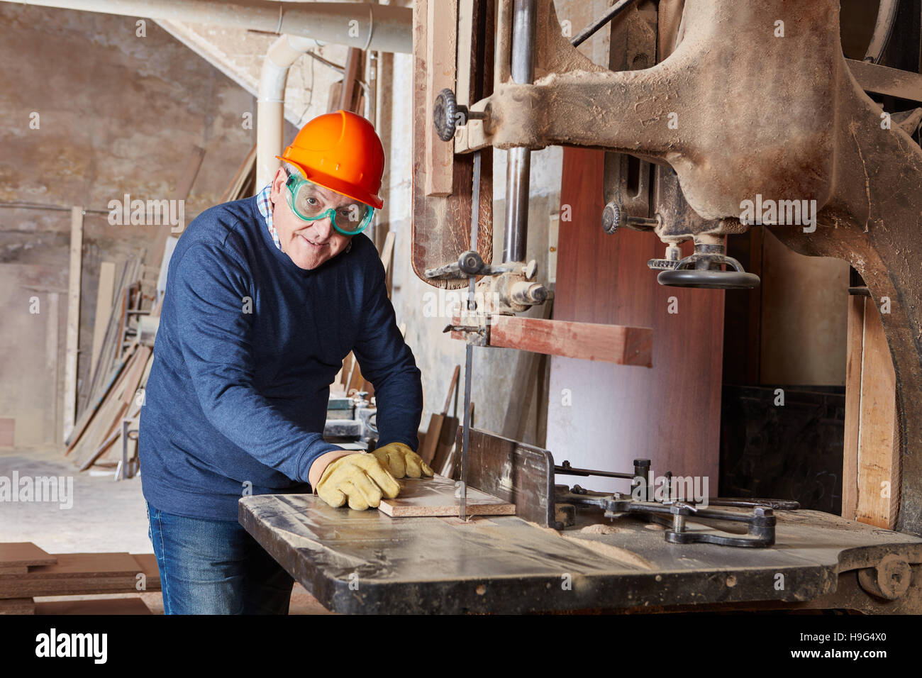 Senior carpenter with competence working on band saw Stock Photo