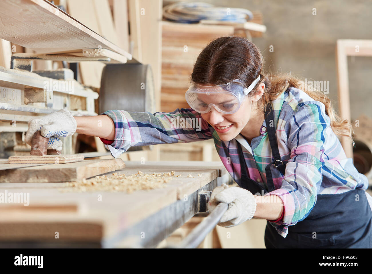 Woman as joiner grinding wood Stock Photo