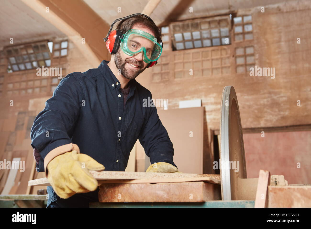 Joiner with grinding machine at carpentry workshop Stock Photo