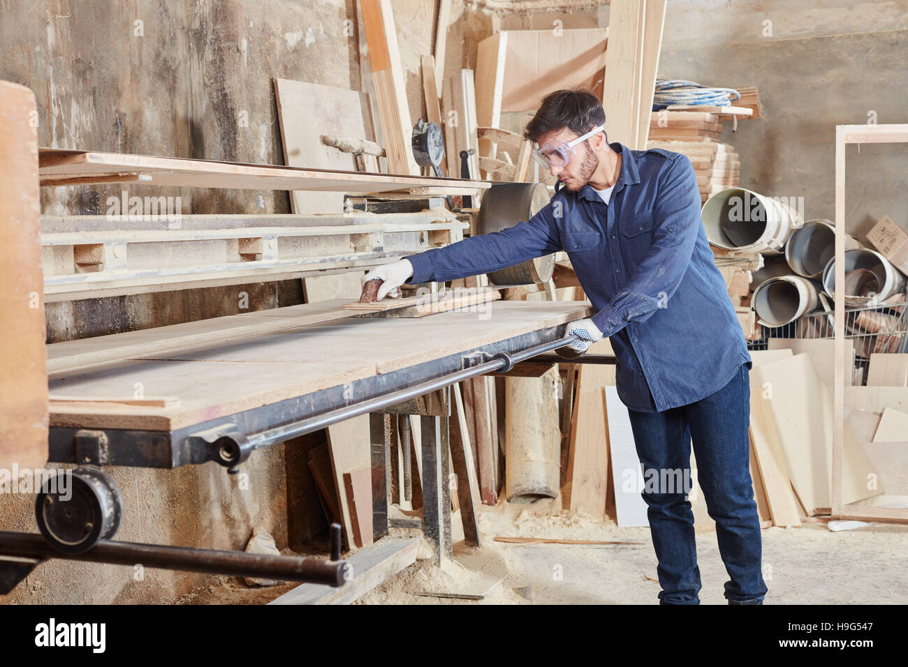 Craftsman using band grinder to cut wood Stock Photo Alamy