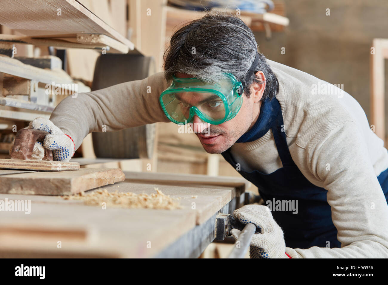 Joiner grinding wood with concentration Stock Photo