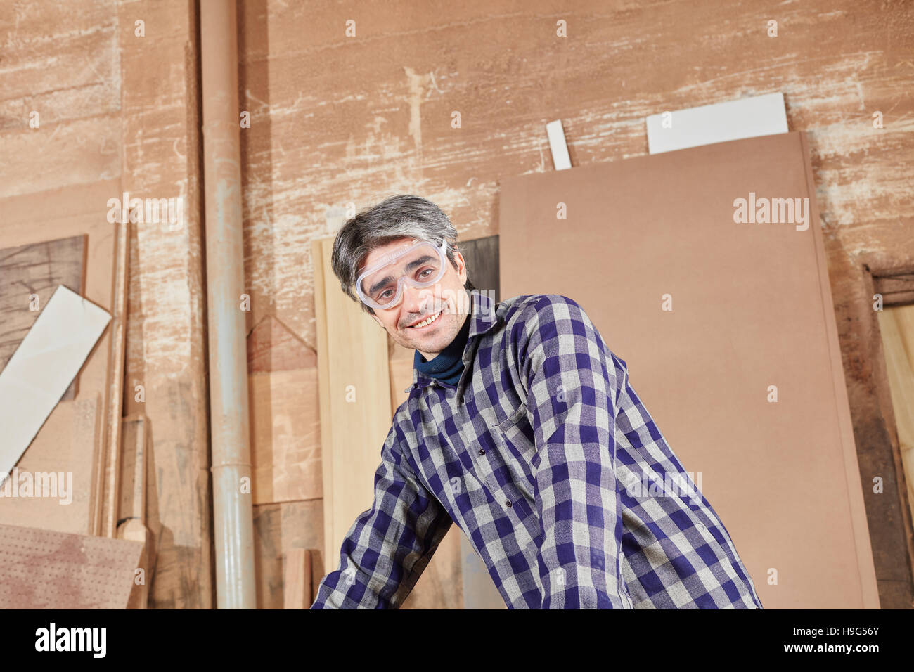 Blue collar worker at workshop working with wood Stock Photo