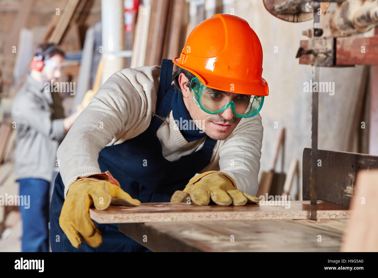 Carpenter cutting wood with accuracy using band saw Stock Photo