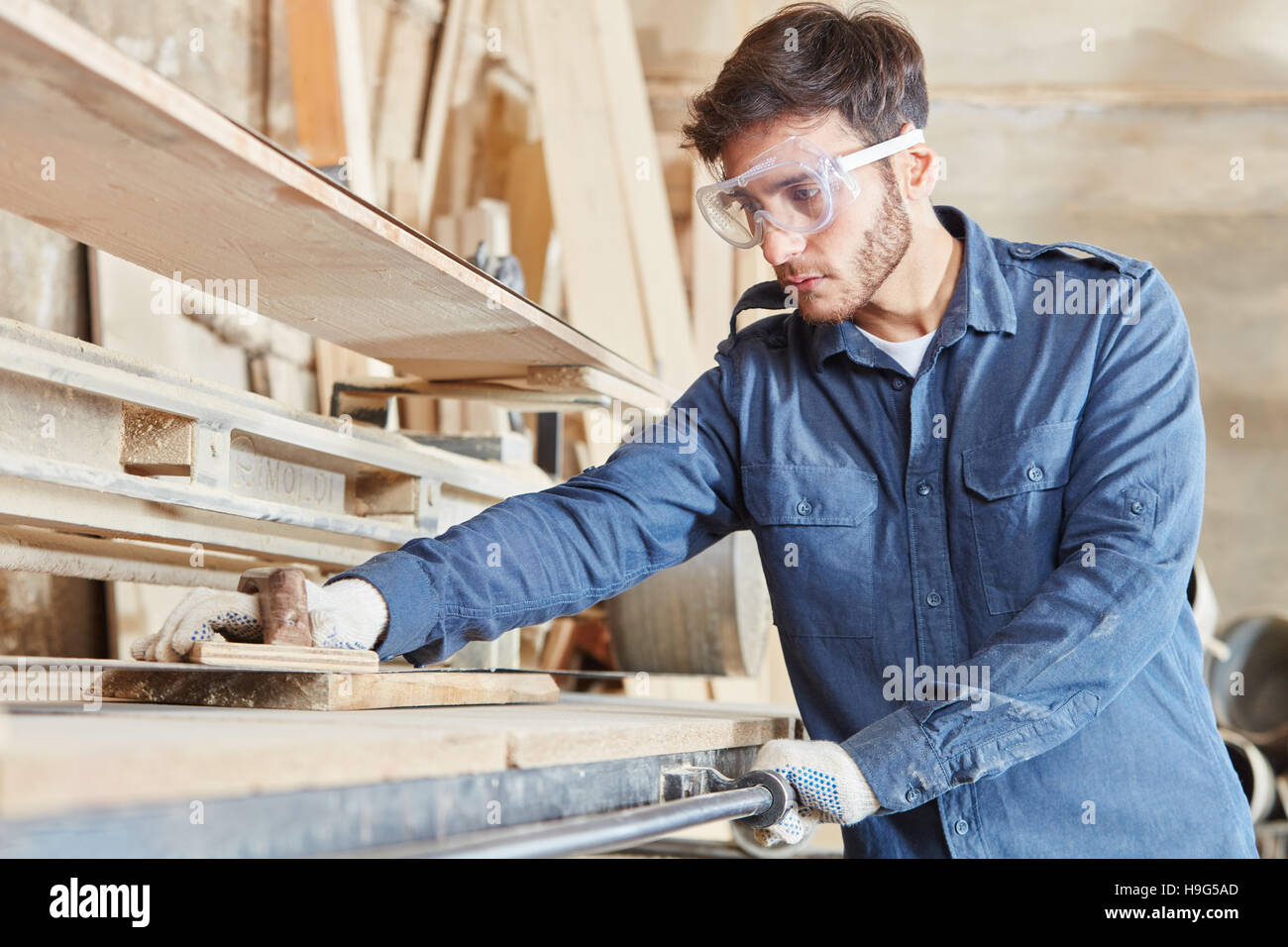 Carpentry apprentice with belt sander grinding wood Stock Photo Alamy