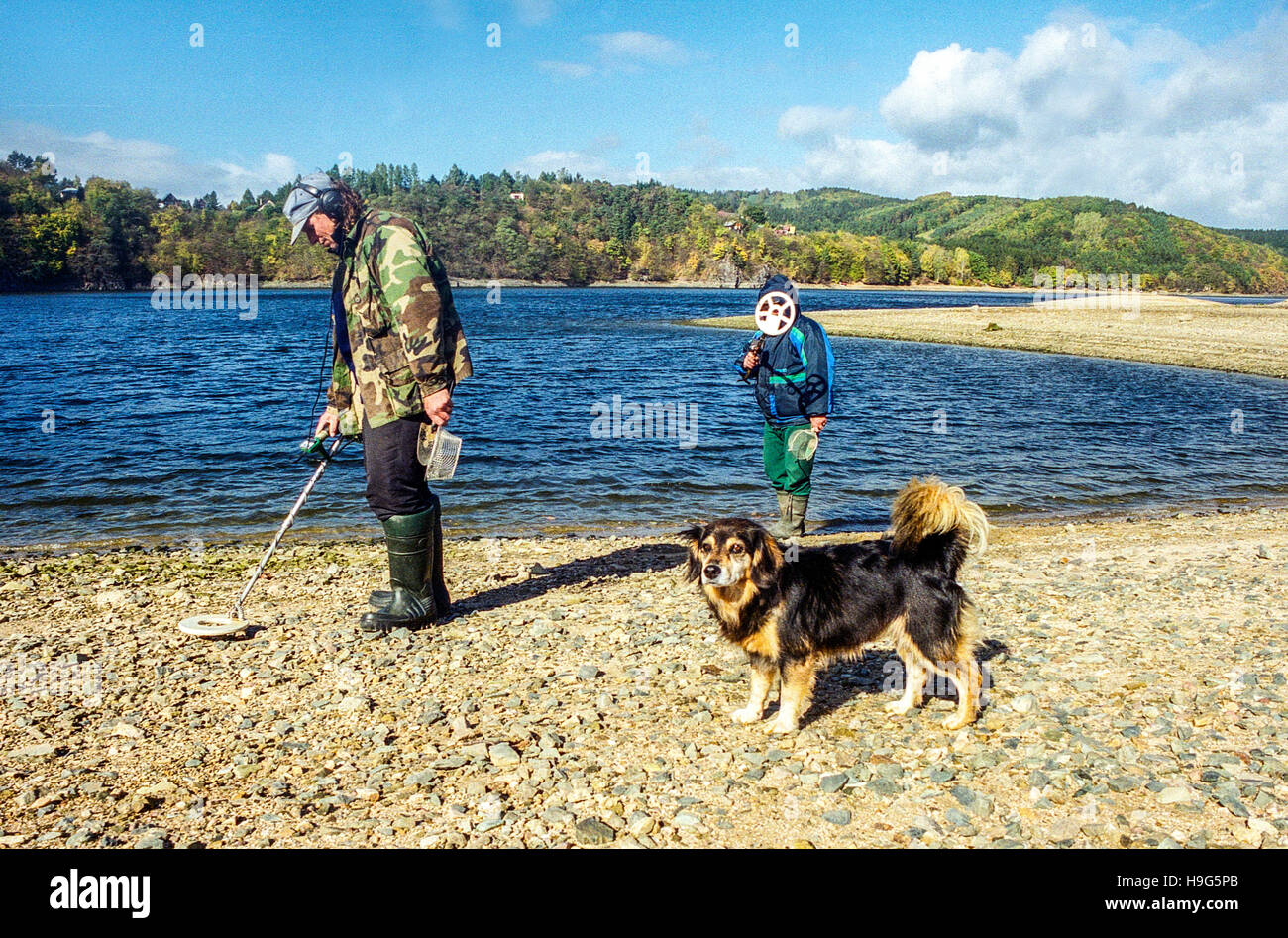 Men with metal detector searching items on the bank of the dam Orlik, Czech Republic Stock Photo