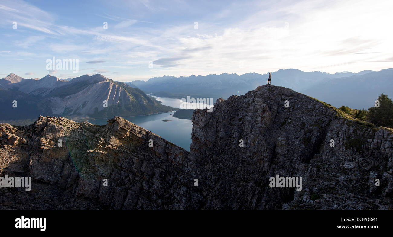 Young man looks out from the peak of a mountain Stock Photo - Alamy