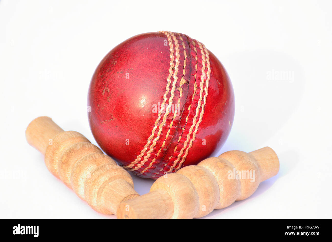 Cricket ball and bails with a shadow on a white background Stock Photo