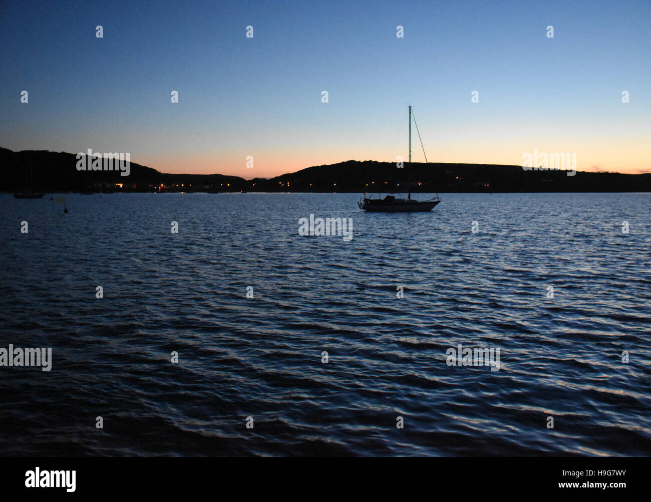 A yacht motors to her anchorage at the end of a day Stock Photo