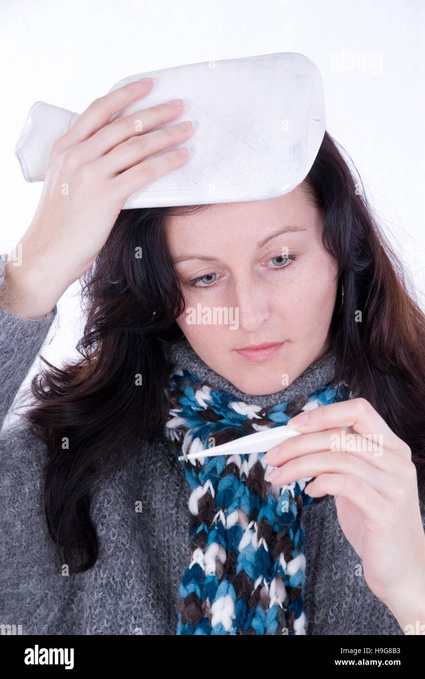 Young woman measuring her temperature Stock Photo