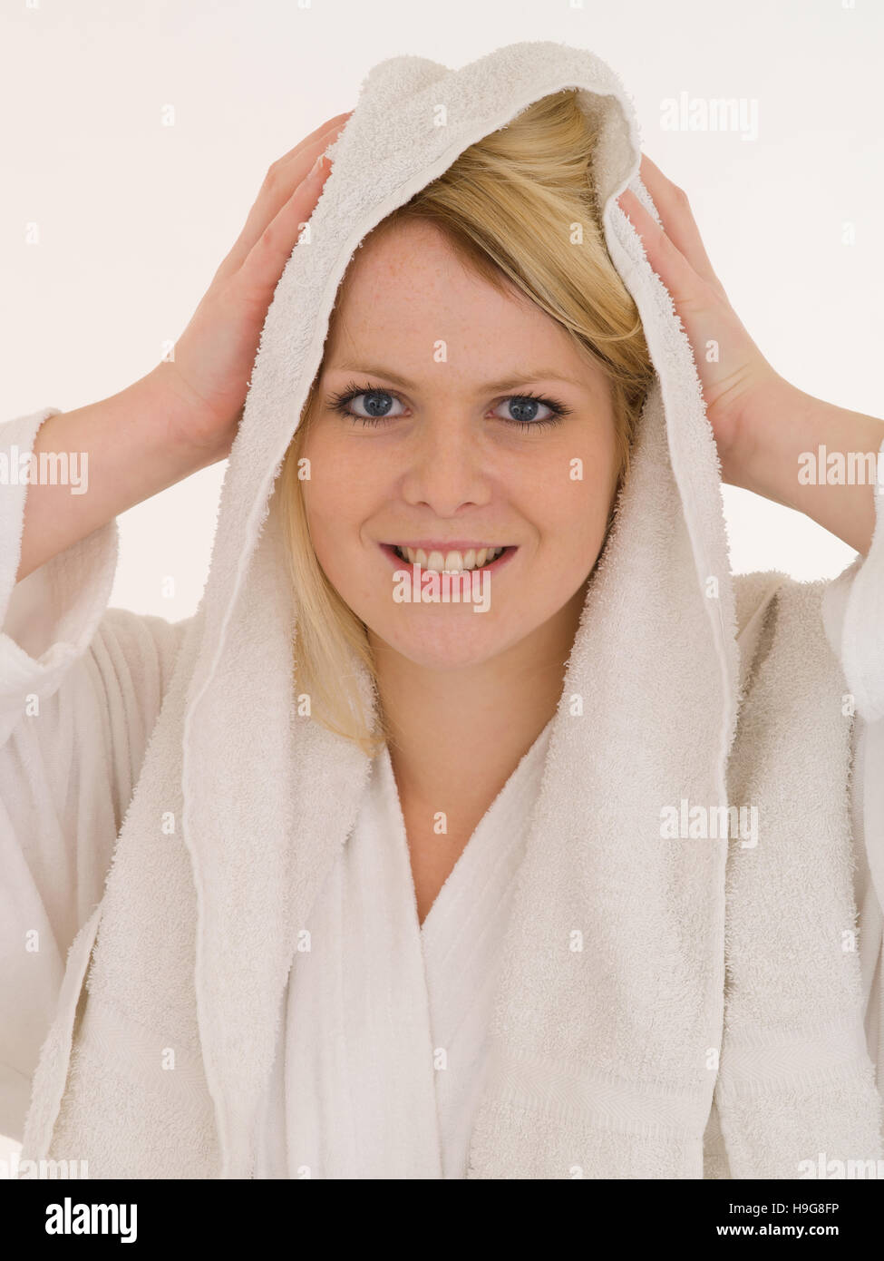 Young woman in a bath robe towelling her hair Stock Photo