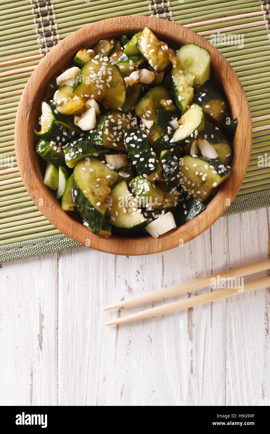 Chinese cucumber salad with sesame seeds close up in a bowl. Vertical view from above Stock Photo