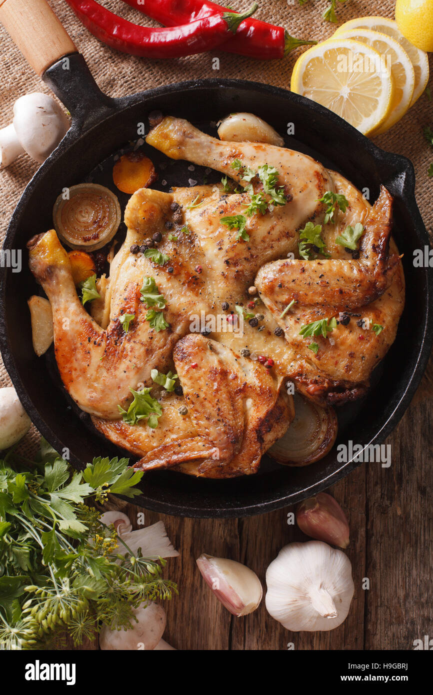 chicken tobacco Fried Chicken tobacco with vegetables close-up on the table. Vertical view  from above Stock Photo