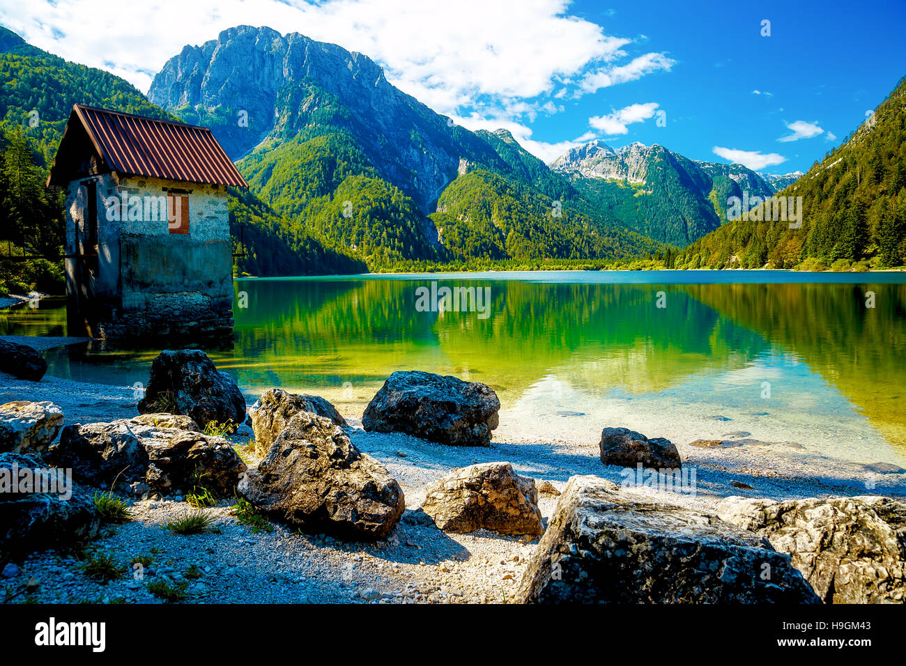 small building at a beautiful lake surrounded by stunning mountain ...