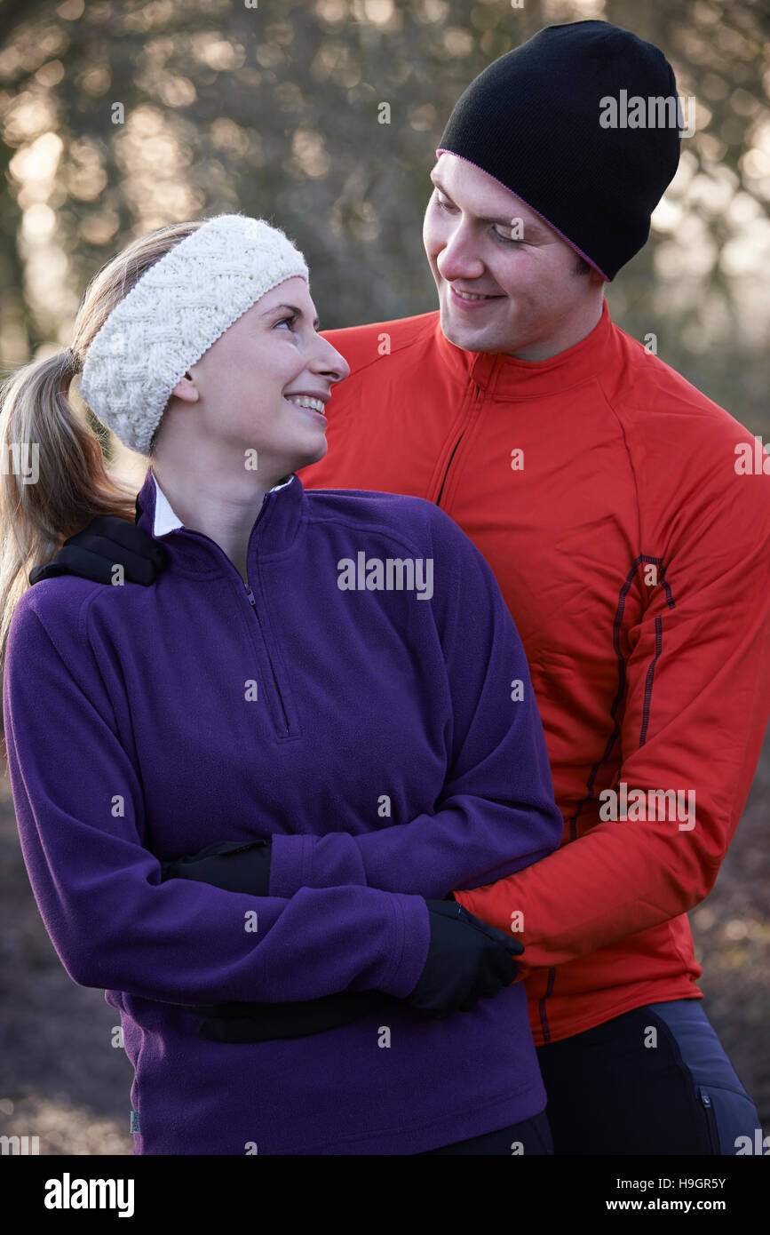 Young Couple On Winter Run Through Woodland Stock Photo