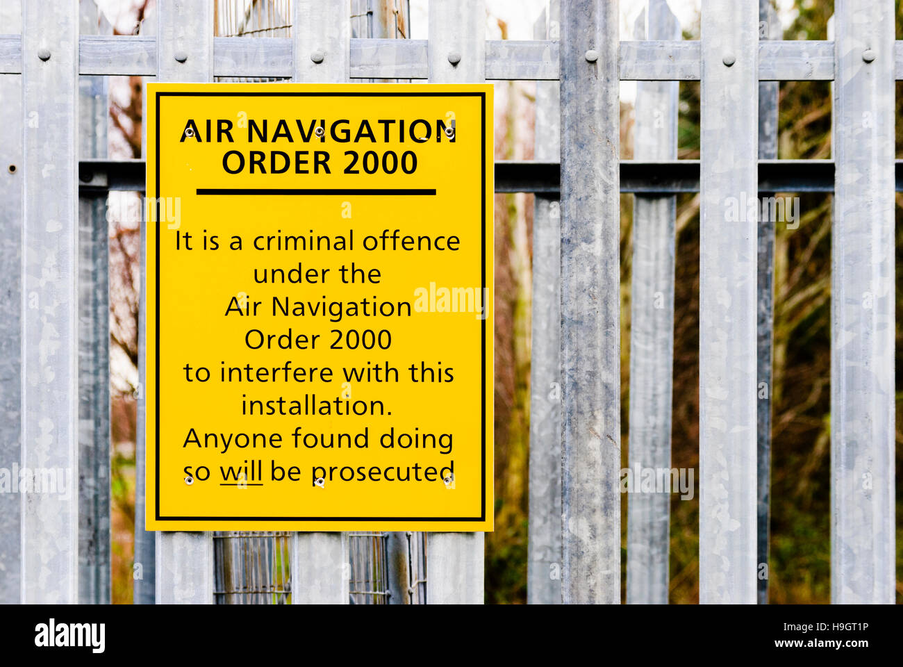 Sign at airport equipment warning that it is a criminal offence under the Air Navigation Order 2000 to interfere with this installation.  Anyone found Stock Photo