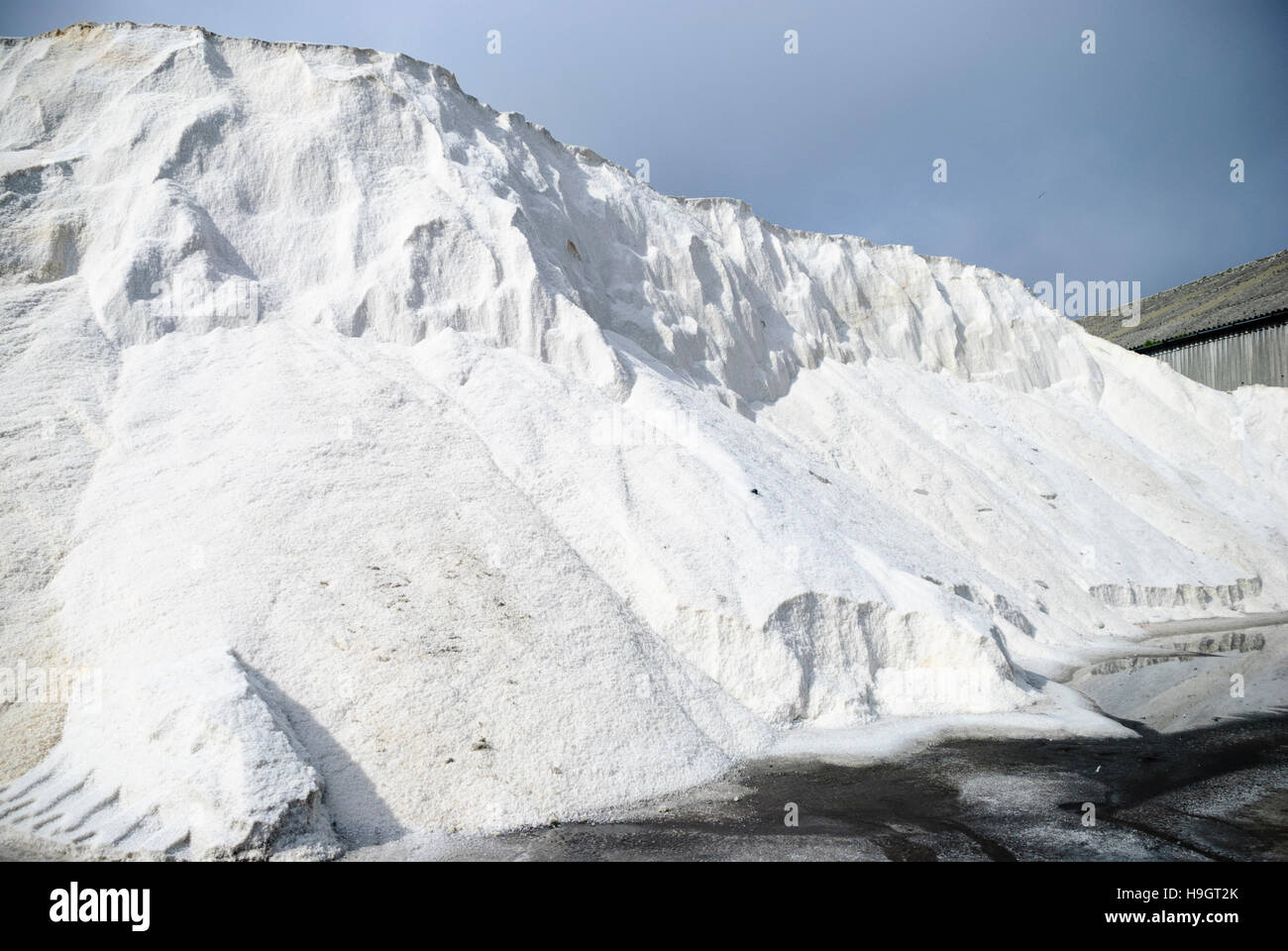Large pile of rock salt (with salt leaching out) for gritting roads in