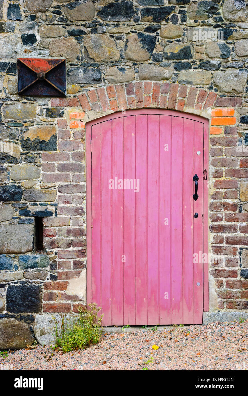 Old red wooden door on stone wall of an old building Stock Photo - Alamy