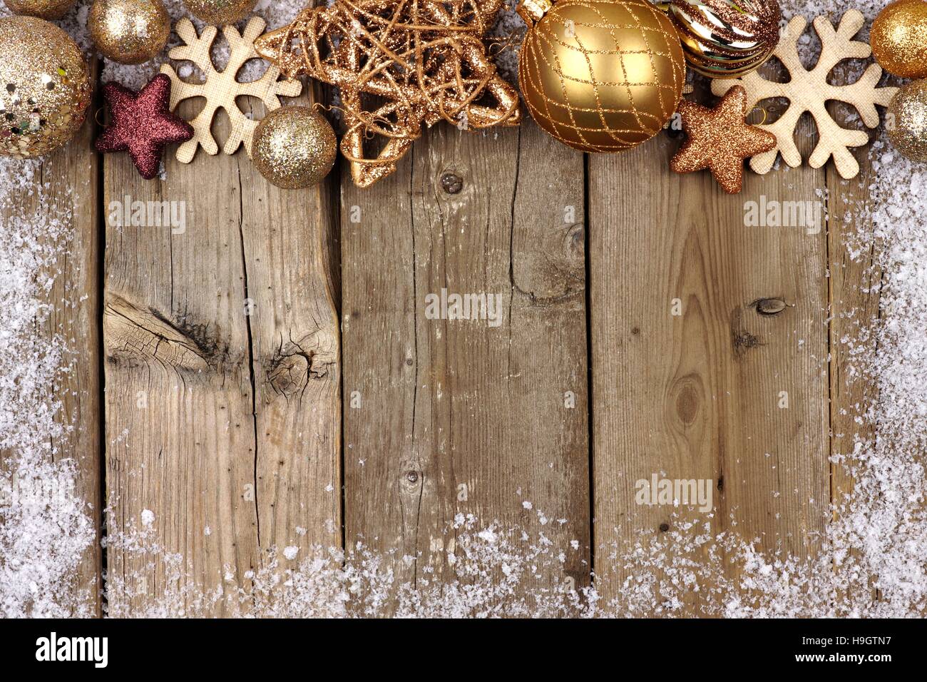 Gold Christmas ornament top border with snow frame on a rustic wood ...