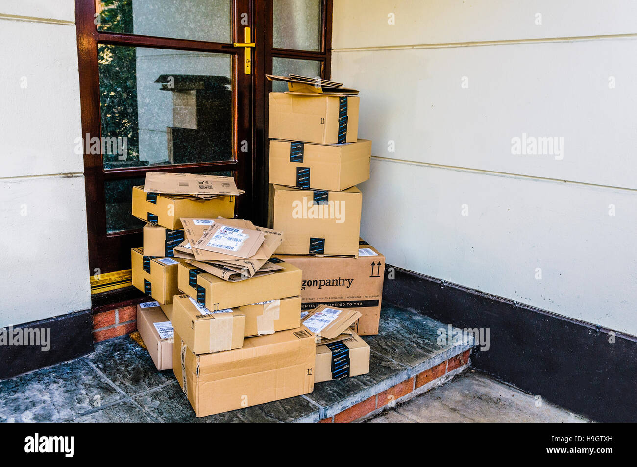 Large quantity of Amazon, Amazon Prime, and Amazon Pantry boxes on the front step of a house after being delivered. Stock Photo