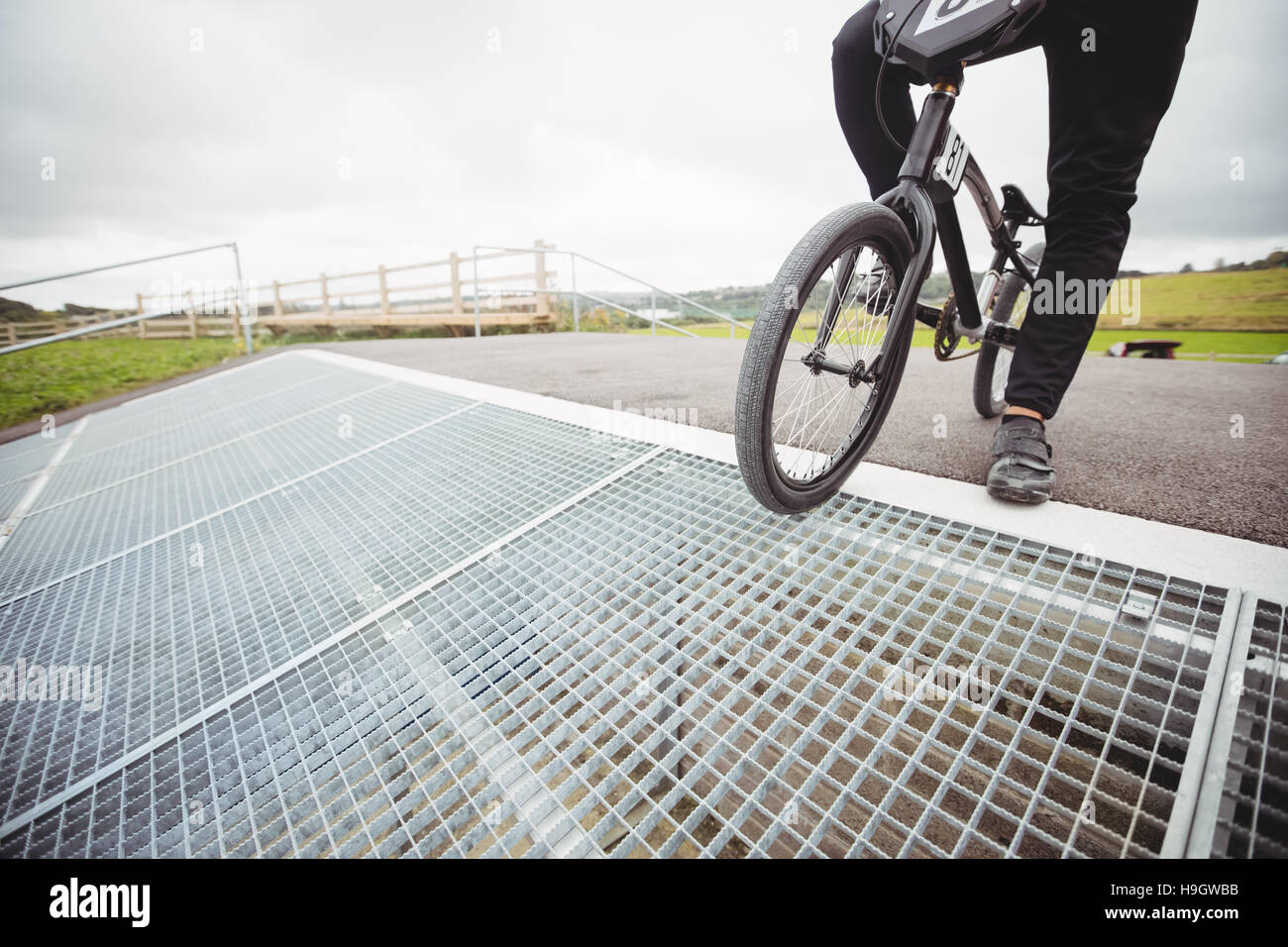 Cyclist standing with BMX bike on starting ramp Stock Photo