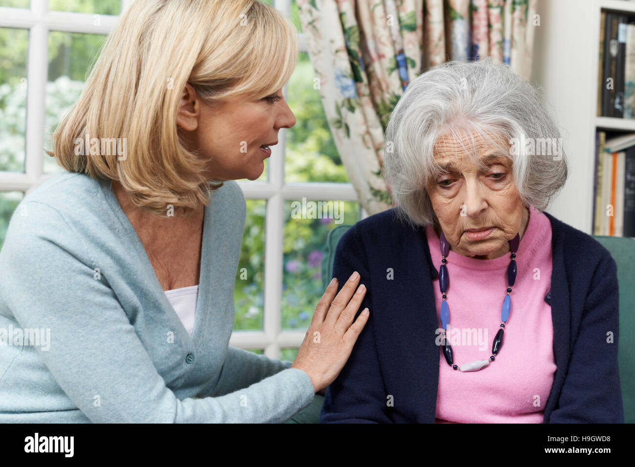 Mature Female Friend Comforting Unhappy Senior Woman Stock Photo