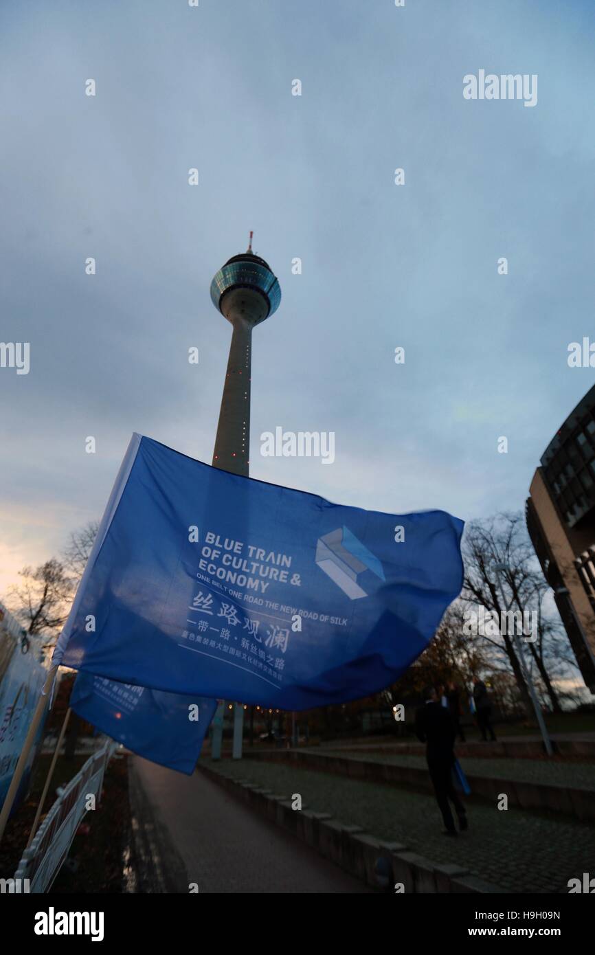 (161123) -- DUSSELDORF, Nov. 23, 2016 (Xinhua) -- Photo taken on Nov. 21, 2016 shows flags near the site of Blue Containers in Dusseldorf, Germany. Some 15 containers have been unveiled under Dusseldorf's landmark, the over-200-meter-high telecommunications tower Rheinturm, to showcase cultural artifacts from the countries along the 'Belt and Road' routes. Launched Monday night under the title of 'Blue Containers' on New Silk Road, the event will last six days and see paintings, handicrafts, and musical instruments, among others, on display in containers marked with national flags of China, Gr Stock Photo