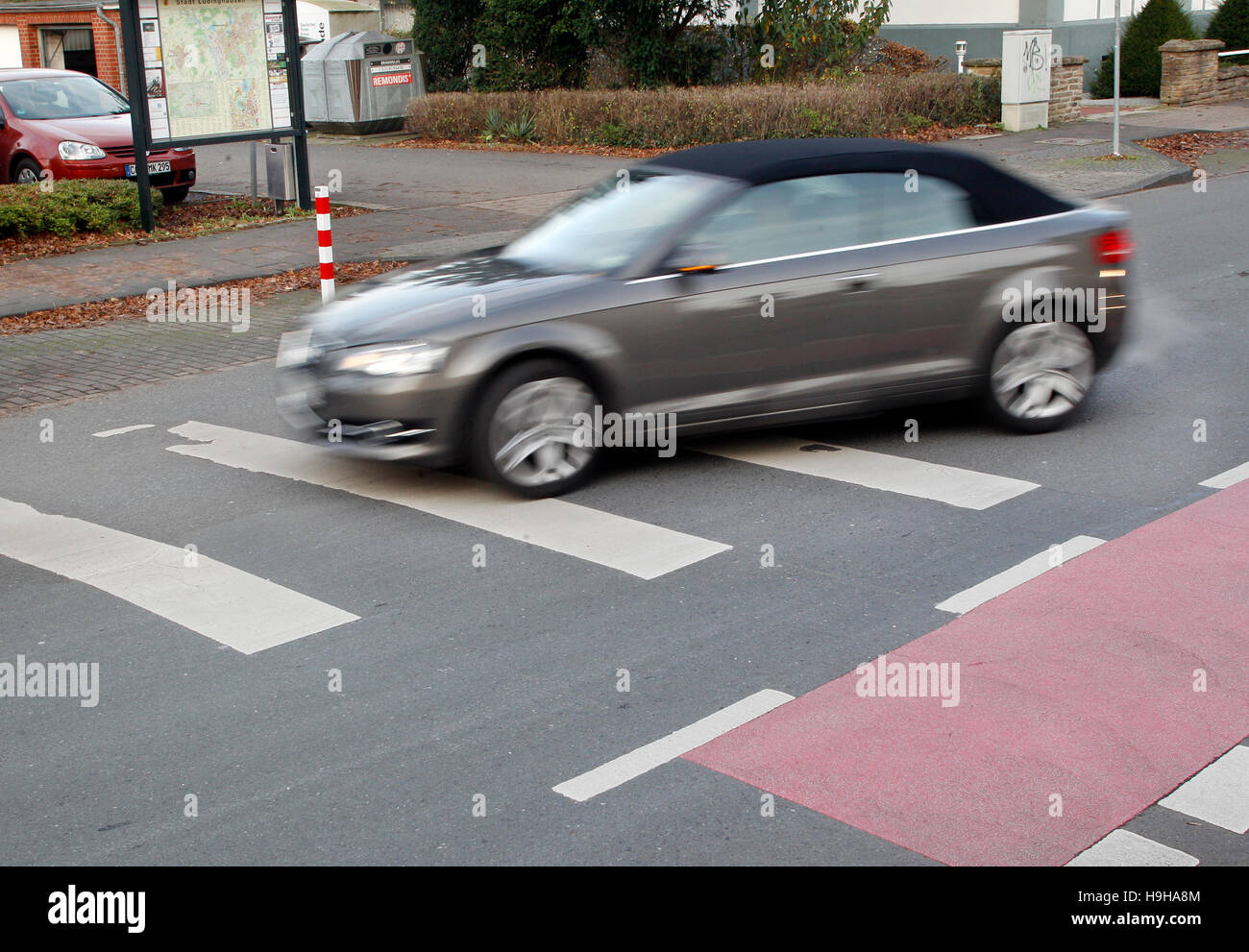 A car drives over a zebra crossing which has been painted the wrong way