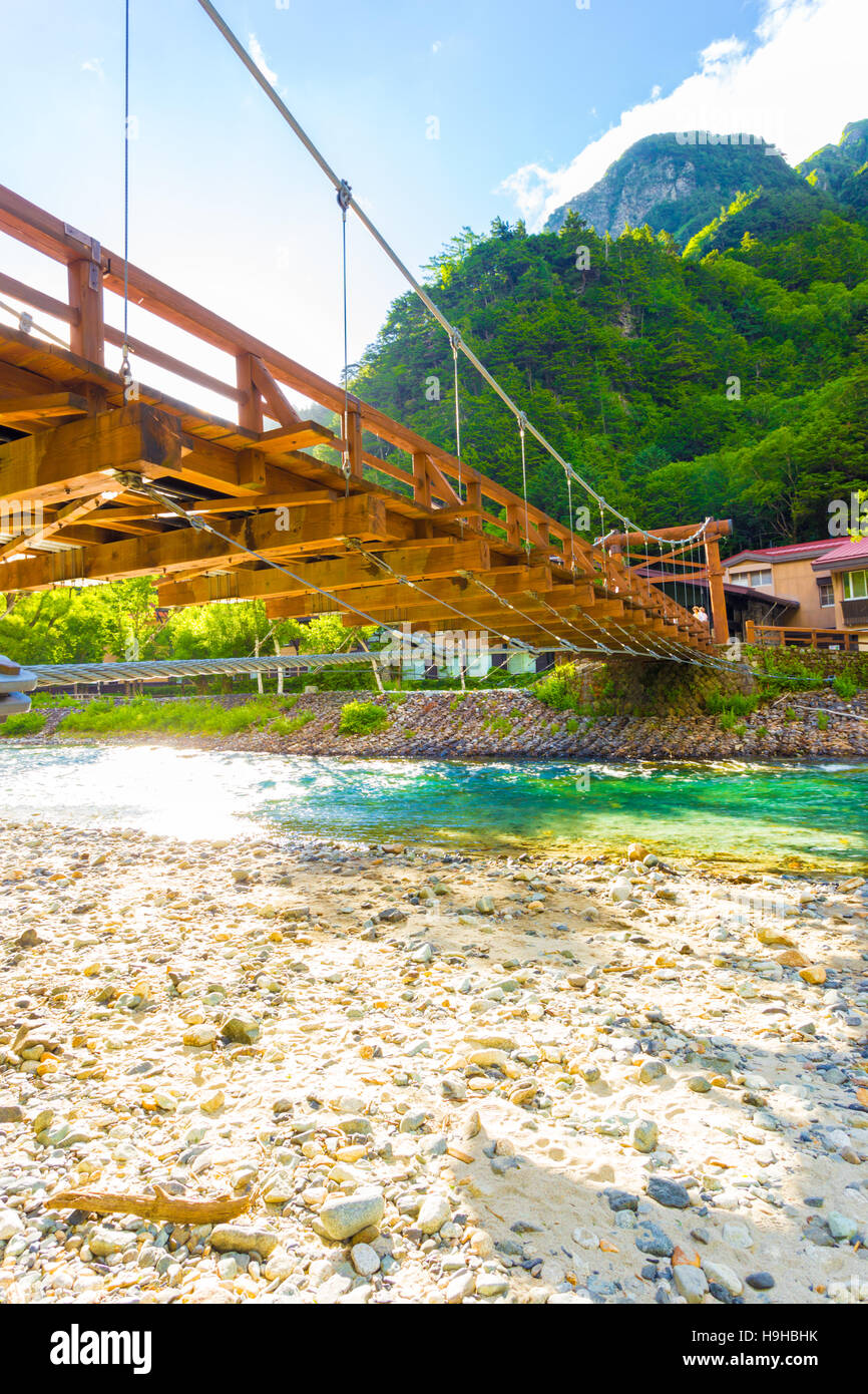 Low angle view from underneath Kappa Bashi Bridge over the clear water of the Azusa River with mountains and sky in Kamikochi Stock Photo