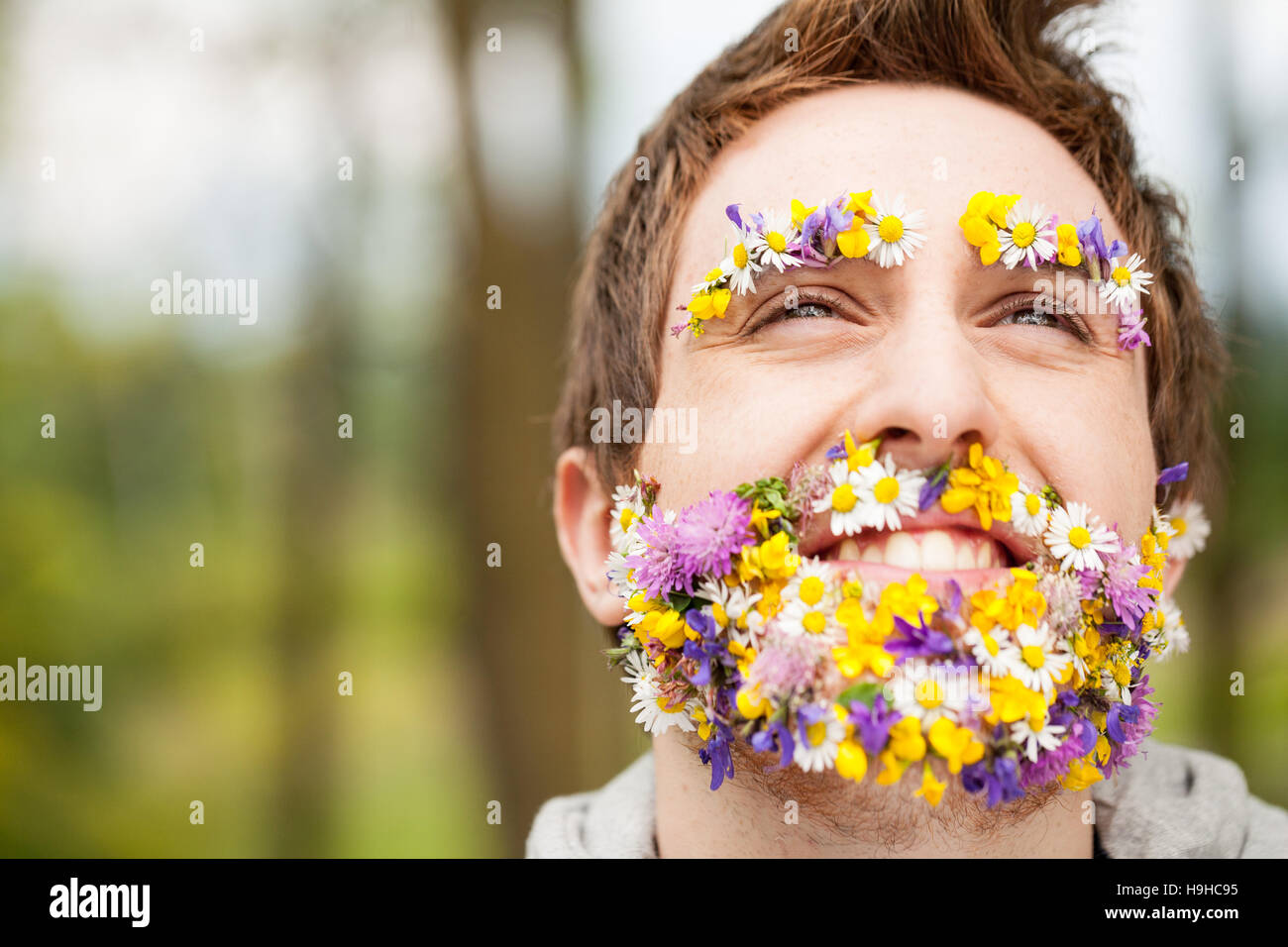 portrait of a guy with flowers instead of his beard relaxed in the