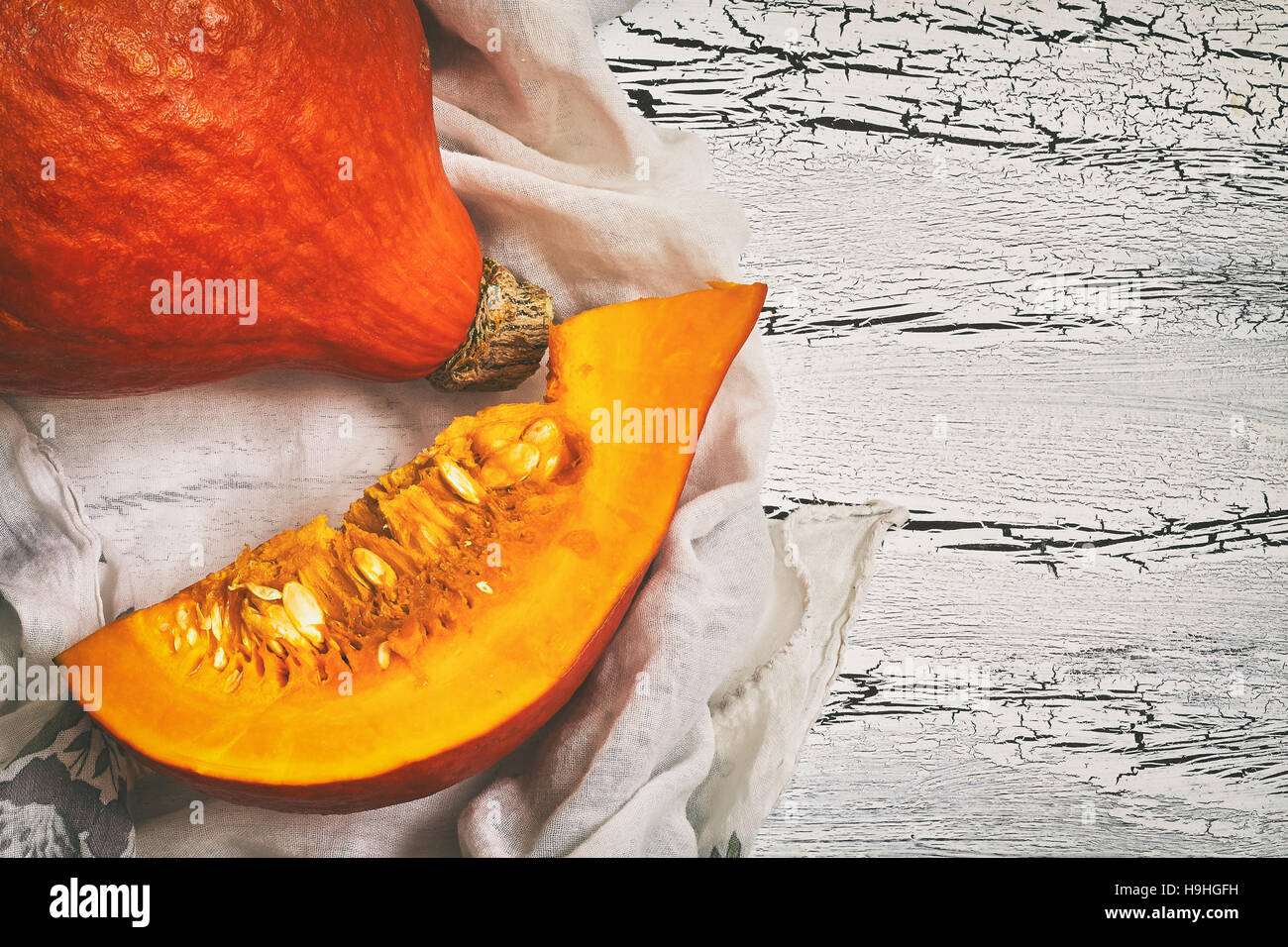 Red kuri squash (Hokkaido pumpkin) on white rustic wooden background ...