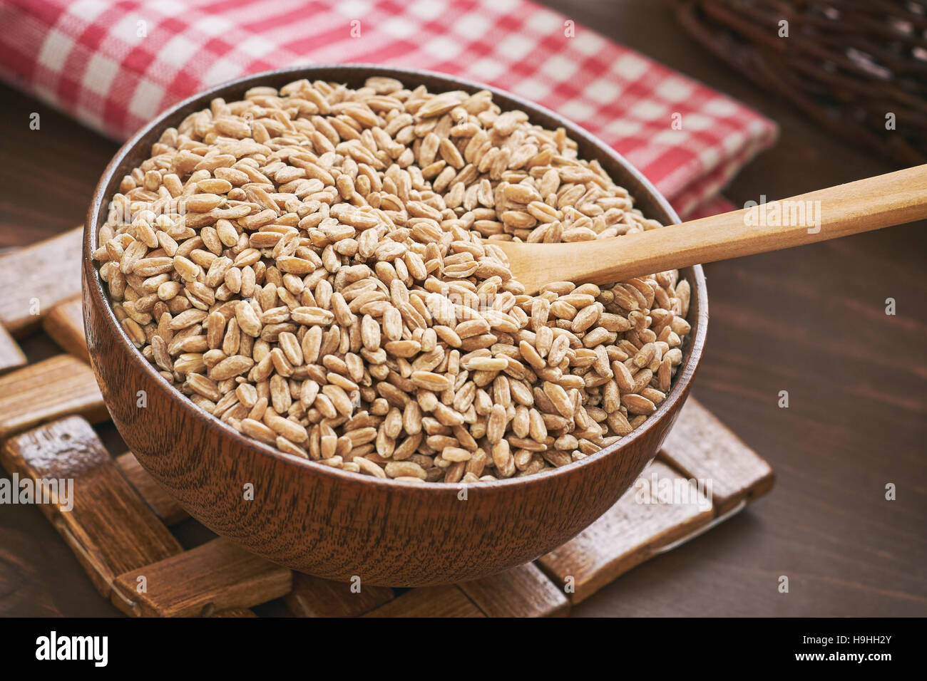 Spelt grain (dinkel wheat) in wooden bowl Stock Photo