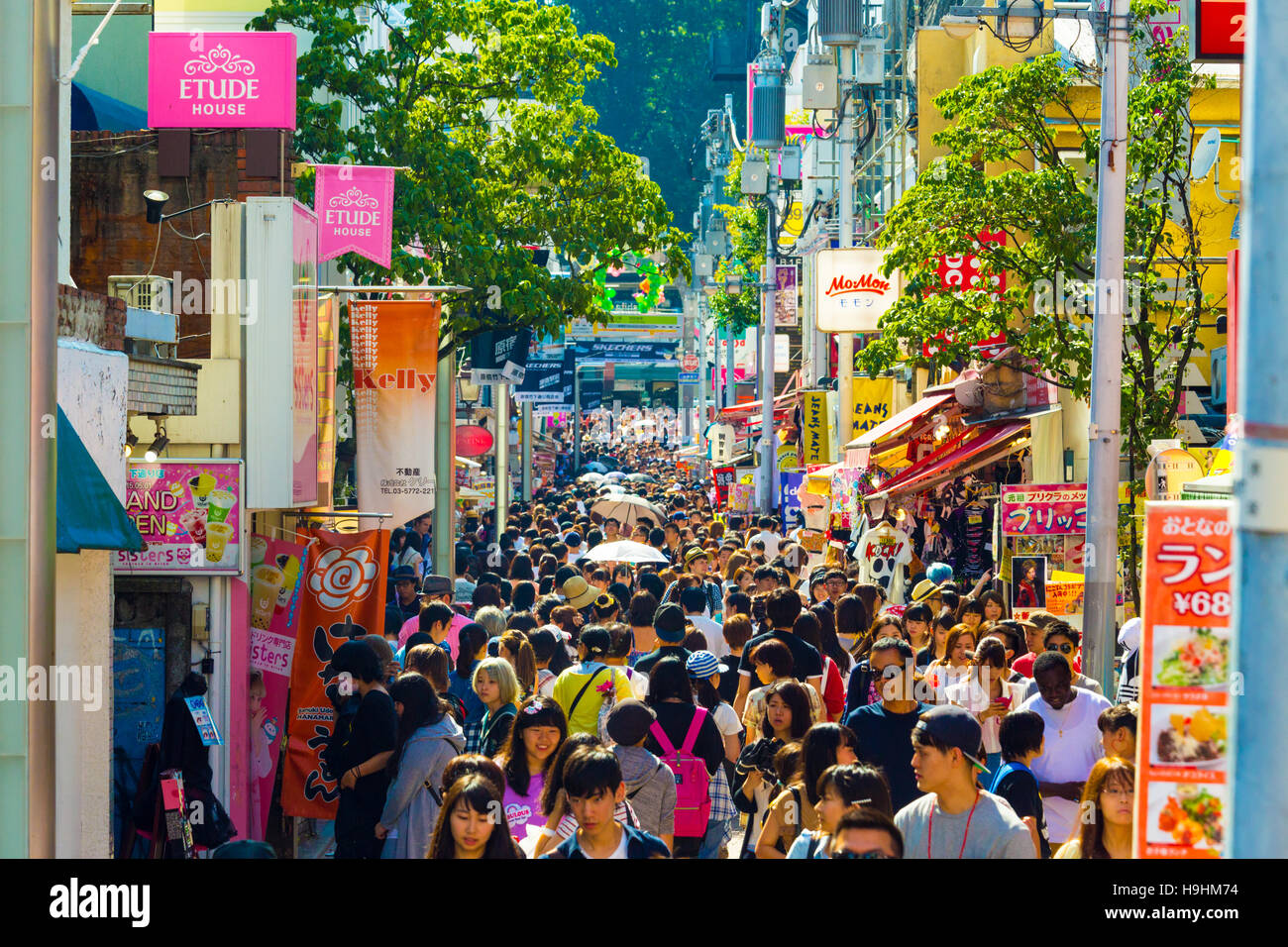 Many young people walking down crowded and bustling shopping street in consumerism mecca lined with stores on busy Takeshita Dor Stock Photo