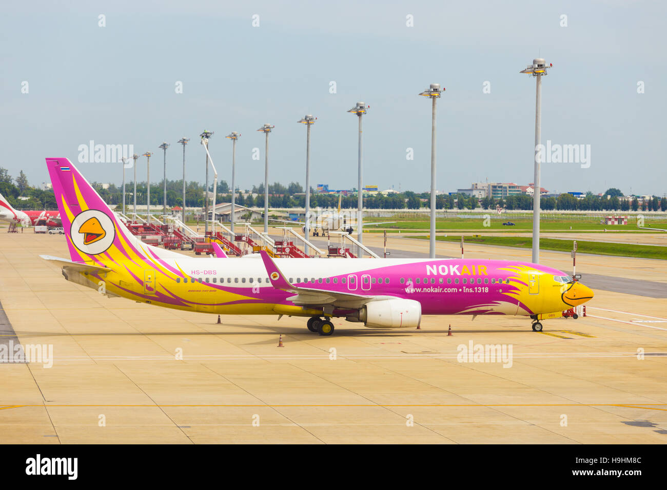 The side of Nok Air airplane parked near the runway at Don Mueang Airport Stock Photo