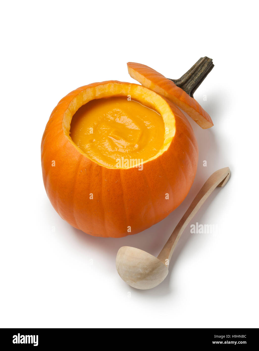 Fresh made pumpkin soup in a orange pumpkin on white background Stock Photo