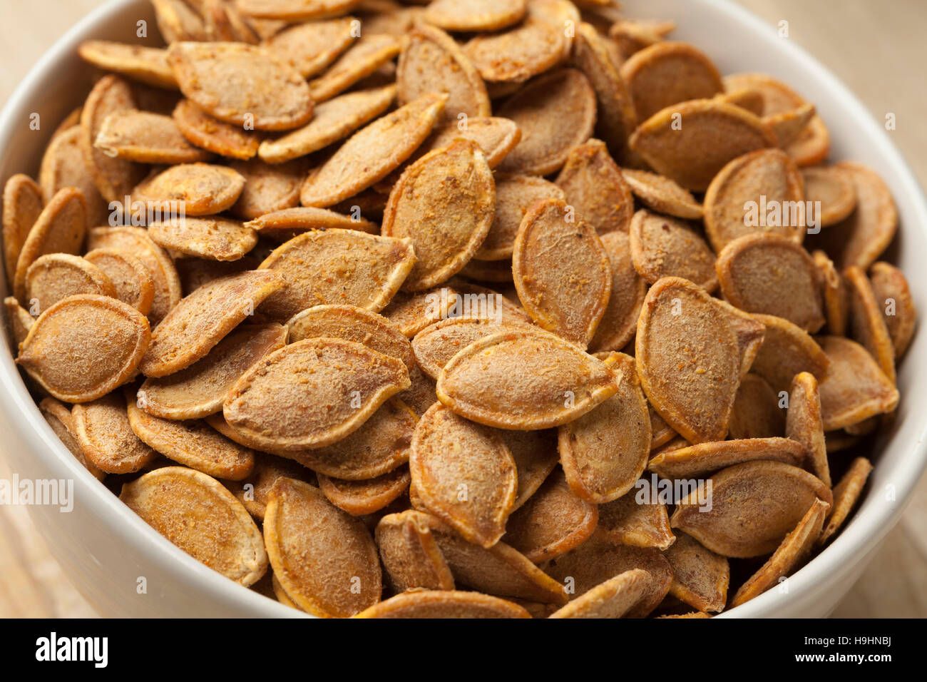 Bowl with spiced roasted pumpkin seeds Stock Photo
