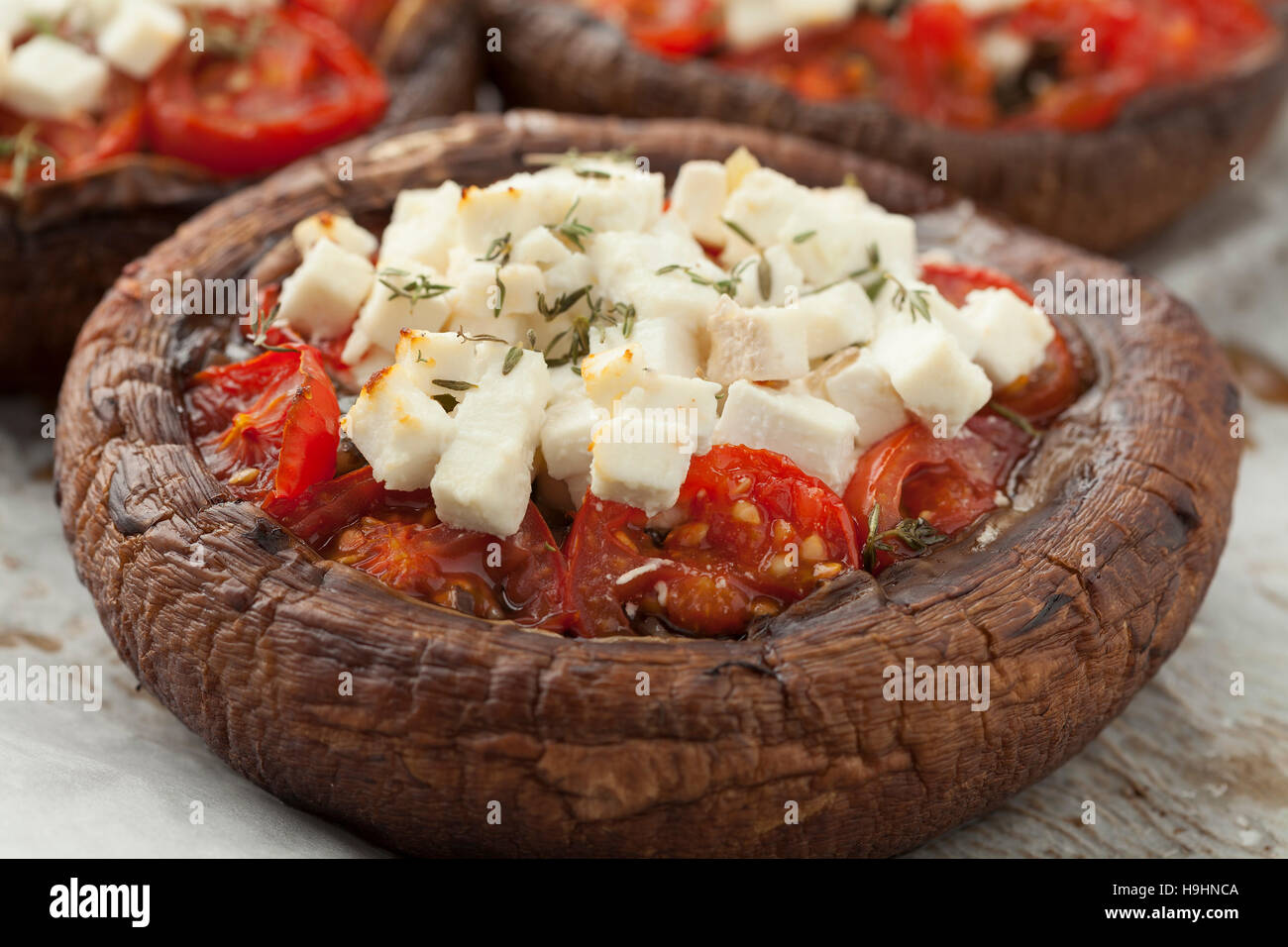 Stuffed portobello mushrooms with feta cheese,tomato and thyme Stock Photo