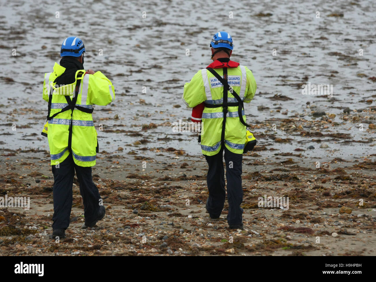 HM Coastguard Search and Rescue officers walk along a beach Stock Photo