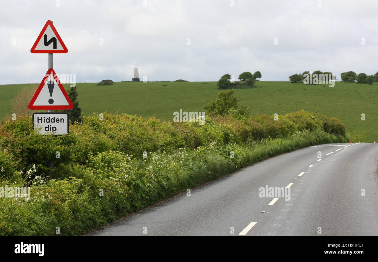 A road sign warns of a hidden dip and twisty bends ahead on a rural road on the Isle of Wight Stock Photo