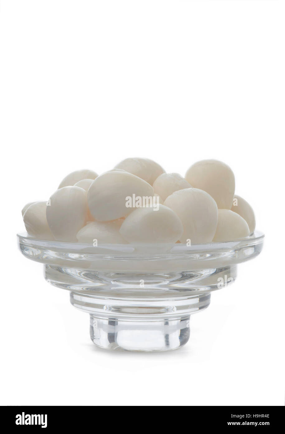 Vertical full frontal view of fresh pickle garlic place on a thick glass dish isolated on a white background with copy space above and below Stock Photo