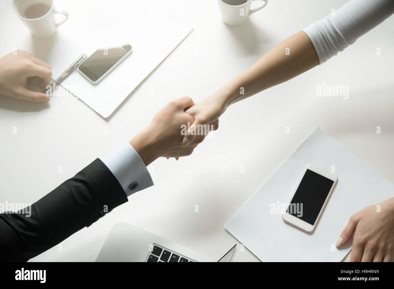 Top view of a handshake between man and woman Stock Photo