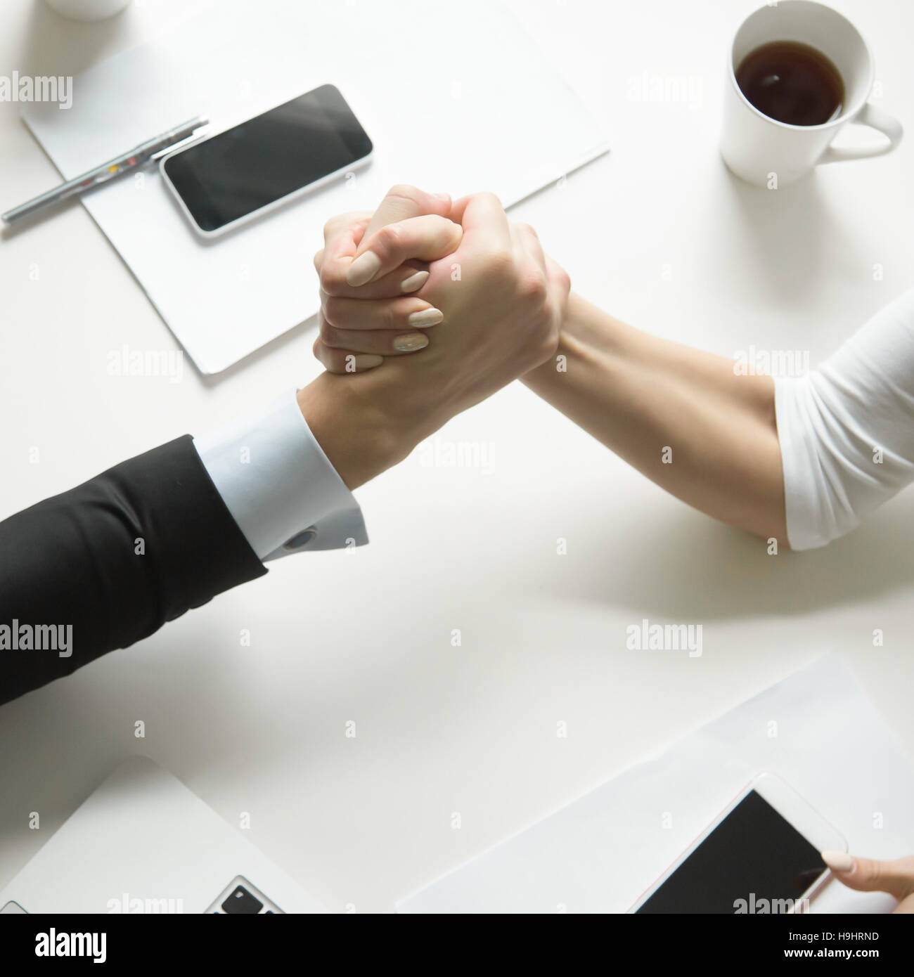 Businessman and businesswoman competing in arm wrestling Stock Photo