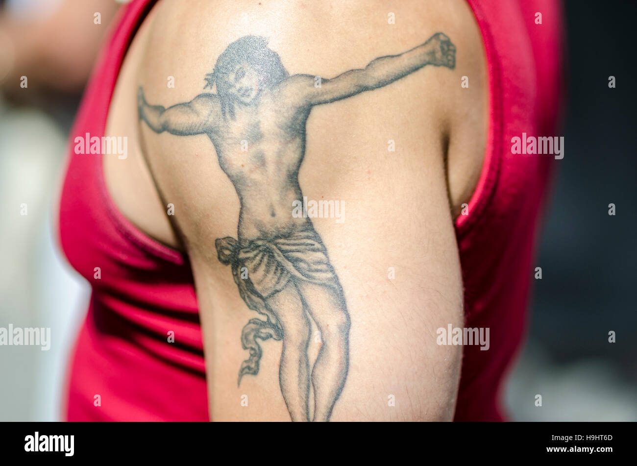 RIO DE JANEIRO - FEBRUARY 28, 2016: A young carioca Brazilian man shows off a large tattoo of Jesus Christ in a crucifixion. Stock Photo