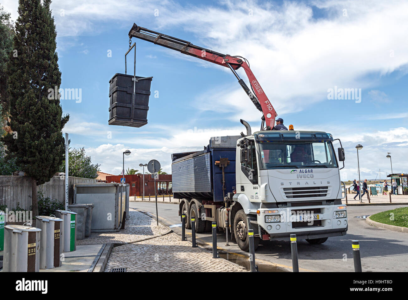 Lorry with lifting arm picking up recycling container, Alvor, Algarve
