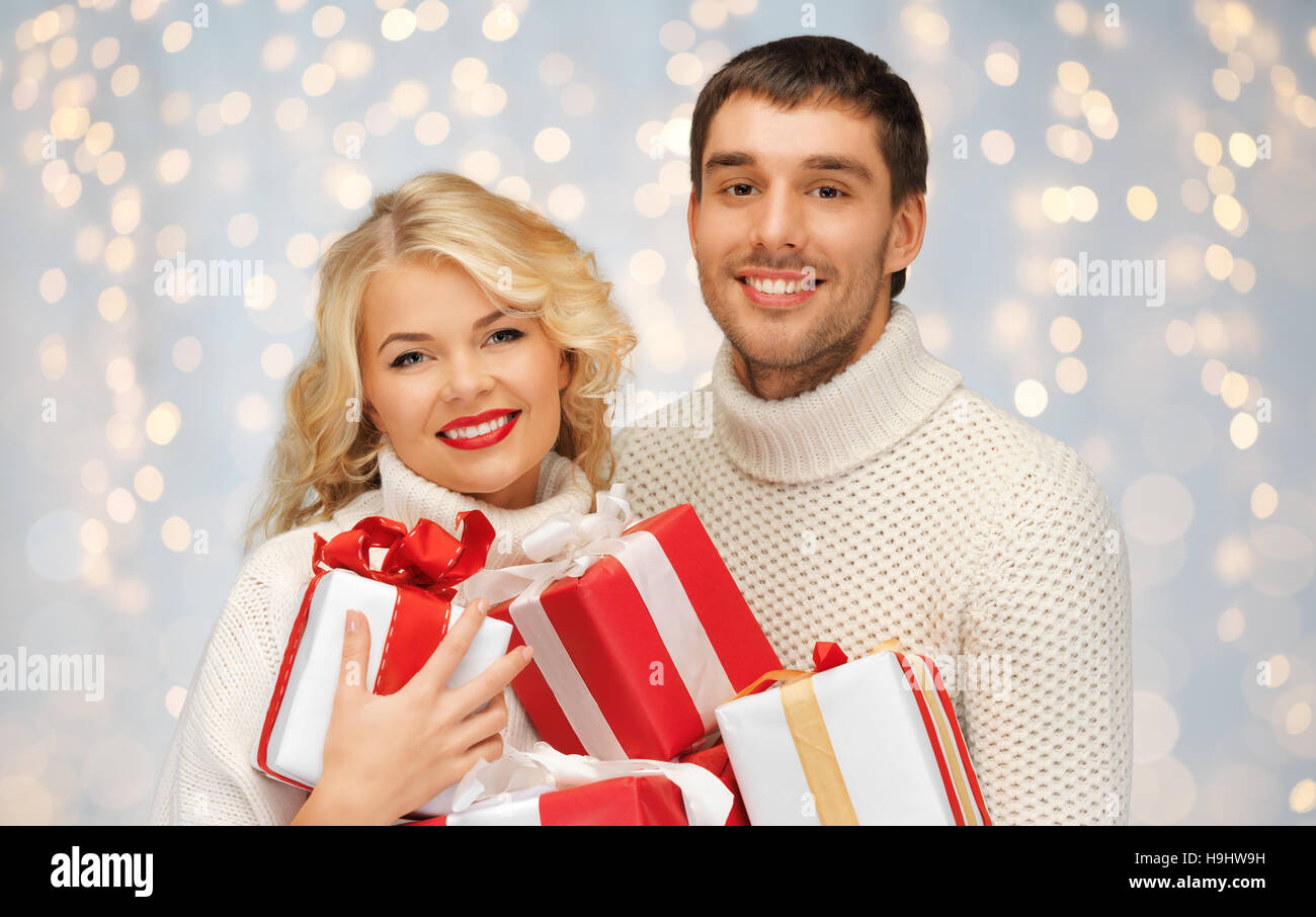 smiling man and woman with presents over lights Stock Photo - Alamy