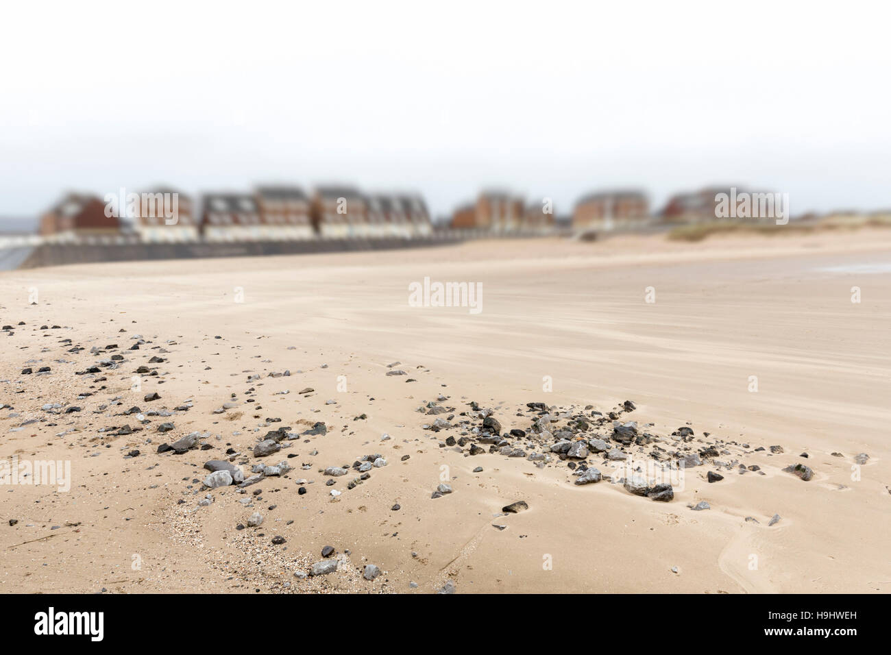 Pebbles on sandy beach with sea front houses, Aberavon, Wales, UK Stock Photo