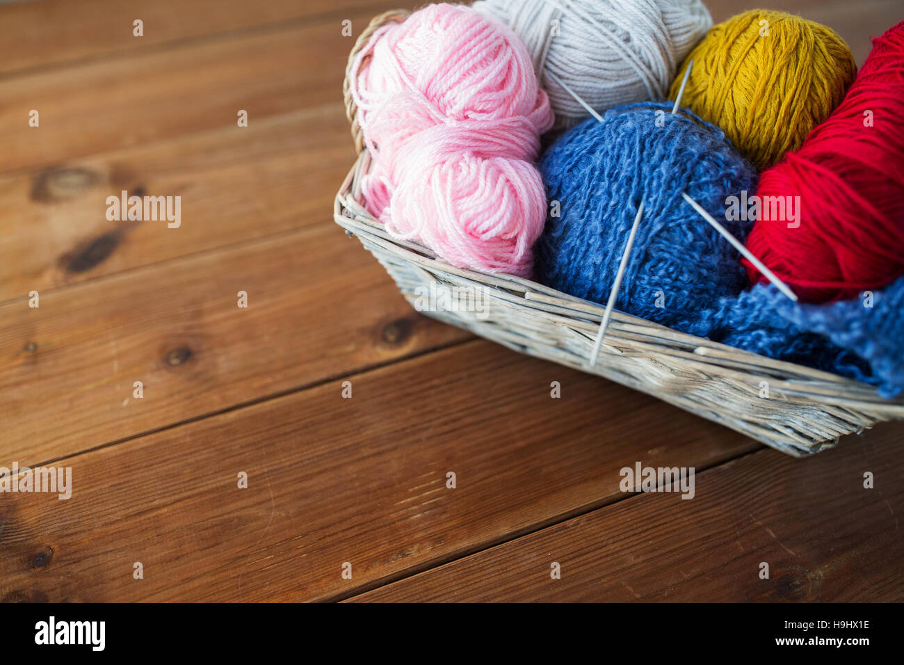 basket with knitting needles and balls of yarn Stock Photo Alamy